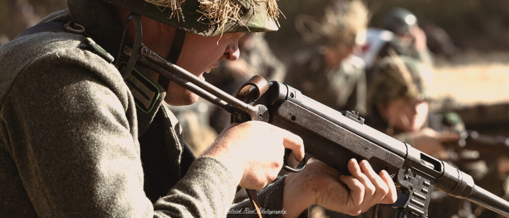 "Close-up view of a World War II MP-40 machine gun, emphasizing its distinctive features. The image captures the metallic texture of the weapon, showcasing the intricate details of the barrel, magazine, and trigger mechanism. The background is slightly blurred, allowing the MP-40 to stand out prominently. Light glints off the surface, highlighting the craftsmanship of this iconic firearm used by German soldiers during the war. The close-up perspective conveys the power and engineering of the weapon, evoking a sense of historical significance."